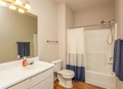 Thumbnail 13 of 27 - A white bathroom with a toilet, sink, and shower.
