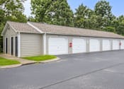 Thumbnail 26 of 27 - A building with a grey roof and white garage doors.