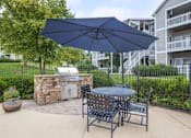 Thumbnail 22 of 27 - A patio with a table, chairs and an umbrella.
