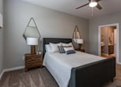 Thumbnail 14 of 38 - A bedroom with a bed, two lamps, and a ceiling fan.