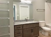 Thumbnail 17 of 38 - A bathroom with a sink, toilet, and a mirror.