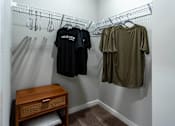 Thumbnail 18 of 38 - A small closet with a shelf and a bench underneath it.