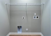Thumbnail 19 of 38 - A white wall with a metal rack and a white door.