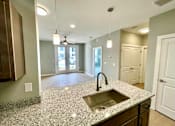 Thumbnail 21 of 38 - A kitchen with granite countertops and a sink.
