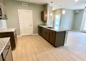 Thumbnail 22 of 38 - A kitchen with a white door and brown cabinets.