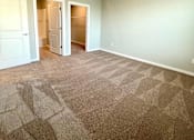Thumbnail 23 of 38 - A room with a carpeted floor and a ceiling fan.