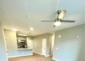 Thumbnail 24 of 38 - A room with a ceiling fan and light fixture.