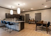 Thumbnail 2 of 38 - A kitchen with a bar area and a dining table.