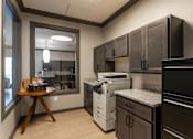 Thumbnail 34 of 38 - A kitchen with black cabinets and a white dishwasher.