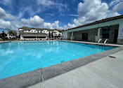Thumbnail 35 of 38 - A large swimming pool with a building in the background.