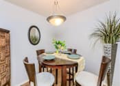 Thumbnail 2 of 32 - A dining room with a round table set for four.