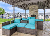 Thumbnail 12 of 32 - A patio with a couch and a fireplace.