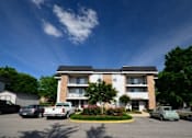 Thumbnail 25 of 25 - A large apartment building with a parking lot in front of it.