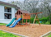 Thumbnail 4 of 25 - A wooden playset with a blue slide in front of a white house.