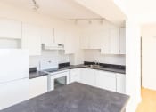 Thumbnail 4 of 7 - a kitchen with white cabinets and a black counter top