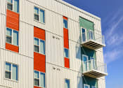 Thumbnail 55 of 74 - a building with colorful doors and balconies and a blue sky