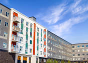 Thumbnail 54 of 74 - a large apartment building with a blue sky in the background