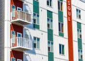 Thumbnail 64 of 74 - a large white building with green and red doors and
