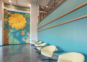 Thumbnail 40 of 74 - a row of white chairs in front of a blue wall with a flower mural