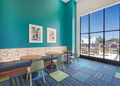 Thumbnail 37 of 74 - a lounge area with tables and chairs and a large window