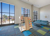 Thumbnail 47 of 74 - a living room with a childs play area and large windows