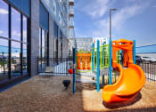 Thumbnail 31 of 74 - a playground with a slide and other toys in front of a building