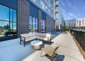 Thumbnail 46 of 74 - a patio with couches and a coffee table in front of a building