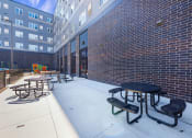 Thumbnail 51 of 74 - a patio with tables and chairs outside of a brick building