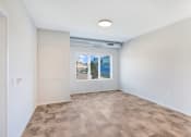 Thumbnail 22 of 74 - an empty living room with a window and white walls