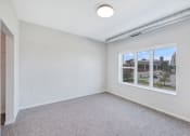 Thumbnail 23 of 74 - an empty room with a window and a carpeted floor