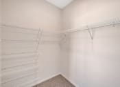 Thumbnail 21 of 74 - the closet of a bedroom with two shelves in it and white walls