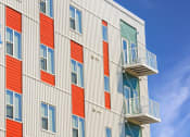 Thumbnail 67 of 74 - a tall building with red and white facade and balconies