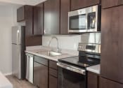 Thumbnail 18 of 61 - Kitchen with espresso cabinets and stainless steel appliances
