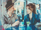 Thumbnail 53 of 61 - a man and a woman sitting at a table in a cafe