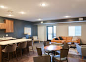 Thumbnail 8 of 21 - A modern kitchen with a dining table and chairs.