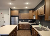 Thumbnail 21 of 21 - A kitchen with wooden cabinets and a white countertop.