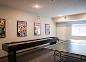 Thumbnail 14 of 21 - A room with a ping pong table and three comic books on the wall.