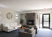 Thumbnail 2 of 21 - A living room with a couch, chairs, and a fireplace.