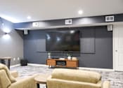 Thumbnail 19 of 21 - A living room with a large screen tv on the wall.