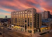 Thumbnail 1 of 24 - a tall building with many windows and a sunset in the background