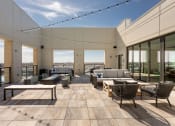 Thumbnail 14 of 24 - Rooftop terrace with couches tables and chairs and a pool in the background at Platform 4611, Illinois