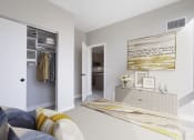 Thumbnail 7 of 24 - a bedroom with grey walls and a large bed with a yellow and white striped blanket at Platform 4611, Chicago, 60640