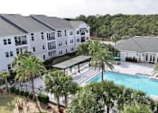 Thumbnail 22 of 28 - A large white building with a pool in front of it.