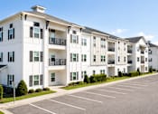 Thumbnail 22 of 22 - A row of white apartment buildings with black balconies and doors.