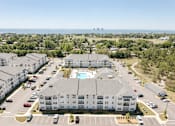 Thumbnail 2 of 22 - A large white building with a pool in the middle of a parking lot.