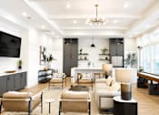 Thumbnail 9 of 22 - A modern living room with a large sofa set, a coffee table, and a TV on the wall.