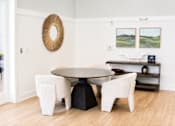 Thumbnail 11 of 22 - A white dining room with a round table and chairs.