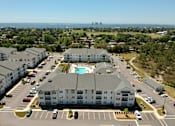 Thumbnail 2 of 28 - an aerial view of a large building with a pool in the middle of a parking lot