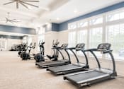 Thumbnail 6 of 22 - A room with a row of treadmills and exercise bikes.