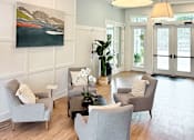 Thumbnail 15 of 28 - A living room with a grey sofa and a painting on the wall.